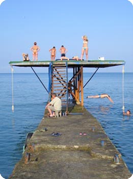 Menschen auf Sprungturm am Meer