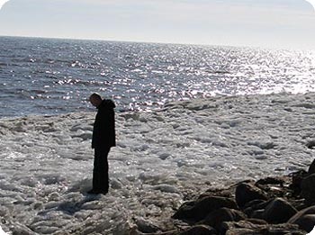 Christian Jahn steht auf Eisdecke am Meeresufer