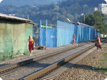 Frau mit rotem Kleid an Bahngleisen