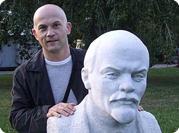 Mann steht hinter Lenin-Skulptur